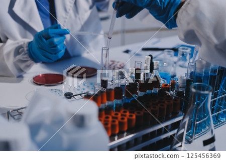 Researcher using a professional microscope Researcher using a professional microscope 125456369