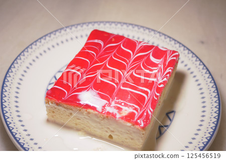 Delicious dessert with colorful jelly topping on a white plate Delicious dessert with colorful jelly topping on a white plate 125456519