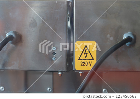 Electrical equipment displaying safety warnings at a workshop Electrical equipment displaying safety warnings at a workshop 125456562