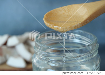 Pouring coconut oil in a jar  125456573
