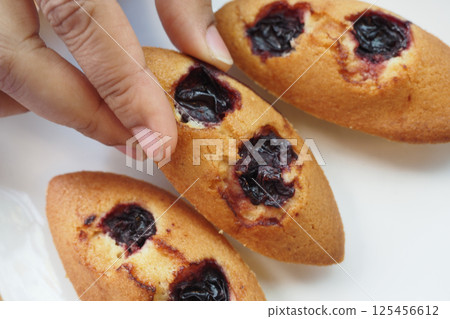 Homemade muffins filled with berry jam on a white plate Homemade muffins filled with berry jam on a white plate 125456612