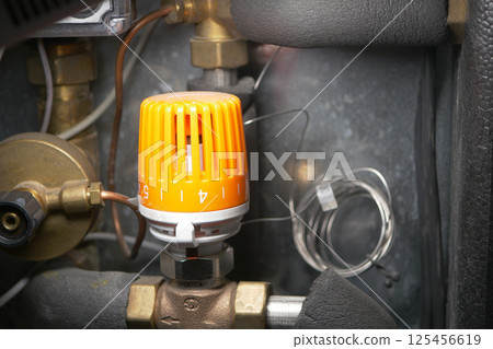 Equipment control valve with orange knob located in mechanical room 125456619