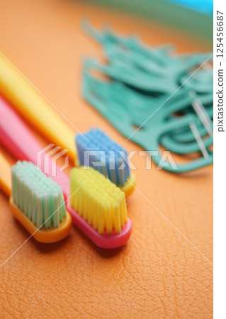 Colorful toothbrushes and dental floss tools on a bright surface 125456687