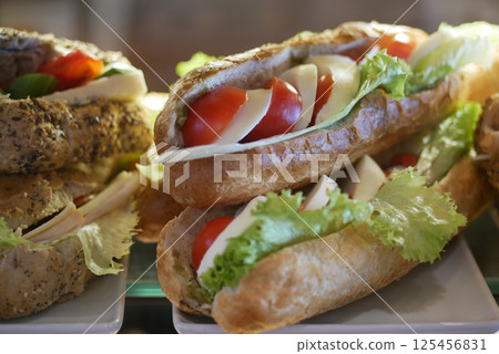 Freshly made sandwiches filled with lettuce and tomatoes in cafe Freshly made sandwiches filled with lettuce and tomatoes in cafe 125456831