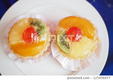 Delicious fruit tarts on a white plate at a dessert table 125456877