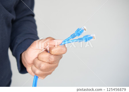 Holding multiple blue network cables for connection setup 125456879
