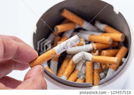 Ashtray with lots of cigarette butts 125457518