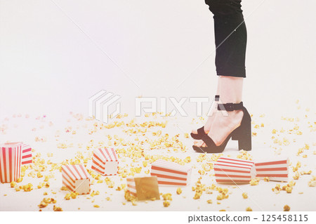 Many popcorn on floor and woman legs background 125458115