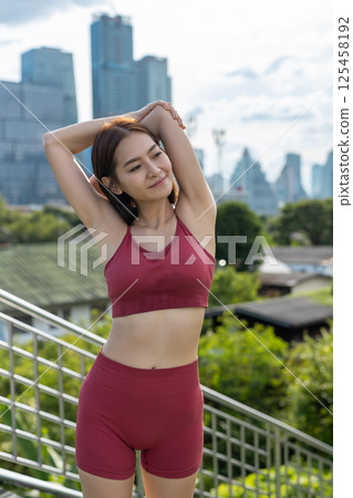 Young beautiful woman sportswear workout clothes using smartphone and listening to music with headphones standing relax in park during exercise the morning. fitness healthy concept. Young beautiful woman sportswear workout clothes using smartphone and listening to music with headphones standing relax in park during exercise the morning. fitness healthy concept. 125458192