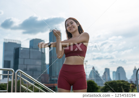Young beautiful woman sportswear workout clothes exercise in street city park before morning run. Asian strong female sporty sportswear stretching outdoors. fitness healthy concept. Young beautiful woman sportswear workout clothes exercise in street city park before morning run. Asian strong female sporty sportswear stretching outdoors. fitness healthy concept. 125458194