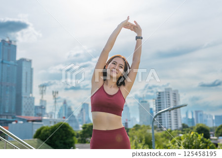 Young beautiful woman sportswear workout clothes exercise in street city park before morning run. Asian strong female sporty sportswear stretching outdoors. fitness healthy concept. 125458195