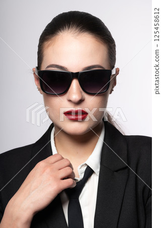 Woman portrait with black suit and sunglasses 125458612