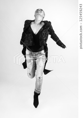 Happy Thai woman with dark clothes and jeans jumping in air Happy Thai woman with dark clothes and jeans jumping in air 125459243