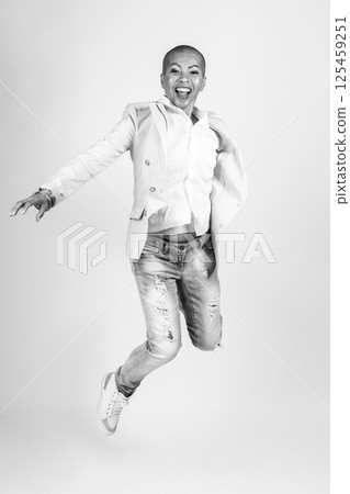 Happy Thai woman with suit and jeans jumping in air Happy Thai woman with suit and jeans jumping in air 125459251