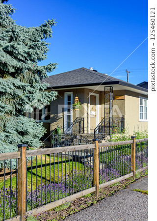 Entrance porch at the corner of residential house with light fence in front 125460121