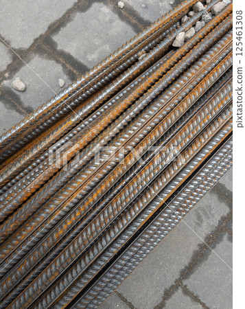 Steel reinforcing bars stacked on paving at construction site 125461308