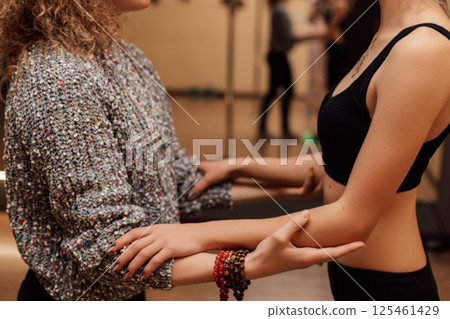 Two women play sports.The trainer supports the client by the hands.Physiotherapy Two women play sports.The trainer supports the client by the hands.Physiotherapy 125461429