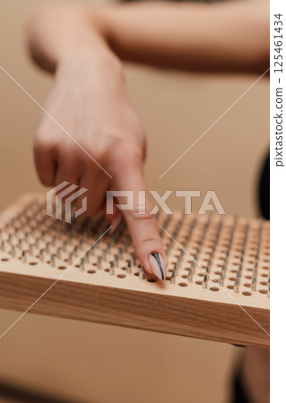 A woman's finger on a sadhu board. Woman holding a board in the hands of a sadhu 125461434