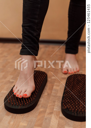 The woman put one foot on the sadhu's board. An attempt to stand on nails 125461435