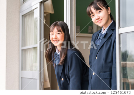 Junior high school girls having a conversation by the window in a school classroom 125461673
