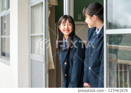 Junior high school girls having a conversation by the window in a school classroom 125461676