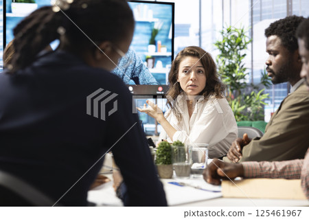 Business colleagues attend an online videocall meeting with a shareholder, presenting the infographics report in order to increase funding. Staff working on global expansion plans. Business colleagues attend an online videocall meeting with a shareholder, presenting the infographics report in order to increase funding. Staff working on global expansion plans. 125461967