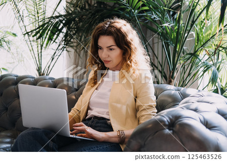 Numerologist working on a laptop in a serene modern lounge space. Modern numerology, digital divination, intuitive analytics, spiritual self-guidance... Numerologist working on a laptop in a serene modern lounge space. Modern numerology, digital divination, intuitive analytics, spiritual self-guidance... 125463526