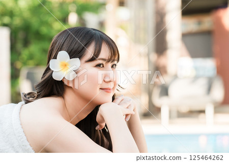 年輕的亞洲女子在泳池邊用手托著下巴（亞洲度假村、休閒場所、水療中心） 125464262