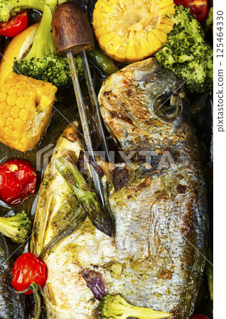 Roasted Dorada fish with vegetables. 125464330
