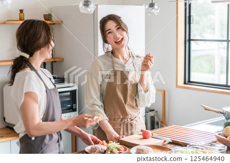 A female instructor and female students teaching cooking at a cooking class/cooking school 125464940