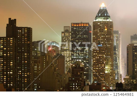 Nighttime New York Skyline With Tall Buildings and Lit Windows 125464981