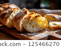 Freshly sliced artisan bread with melting butter, captured in a cozy, rustic setting. 125466270