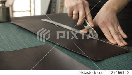 Cutting leather sheet with utility knife Cutting leather sheet with utility knife 125466350