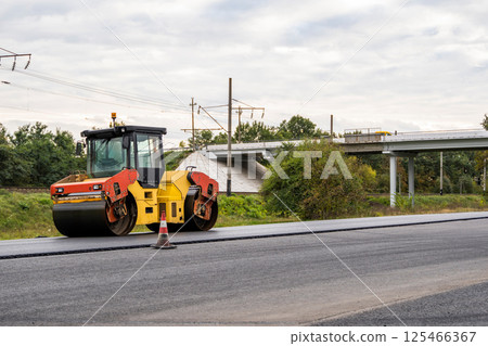 Road roller near bridge during infrastructure project 125466367