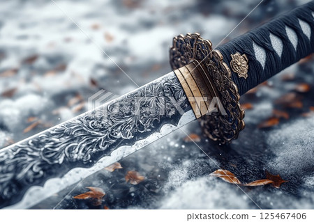 Intricate sword resting on a bed of fallen leaves in a serene winter landscape 125467406