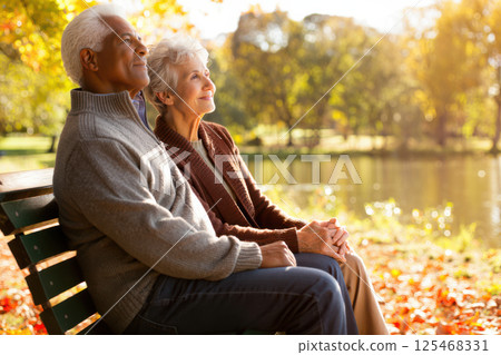 Elderly Couple Holding Hands on Park Bench at Sunset: Timeless Love and Companionship Concept Elderly Couple Holding Hands on Park Bench at Sunset: Timeless Love and Companionship Concept 125468331