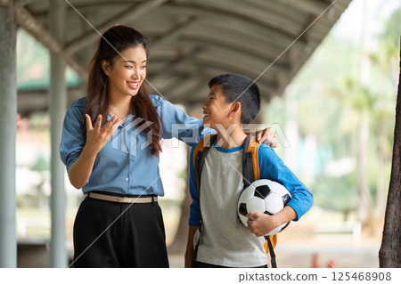 Back to School and Soccer Excitement. A happy student shares a moment with a mentor while walking. 125468908
