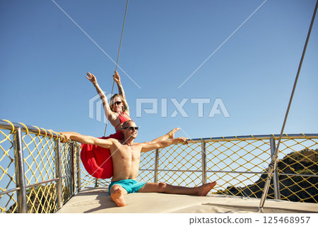 Playful couple posing energetically on yacht deck 125468957