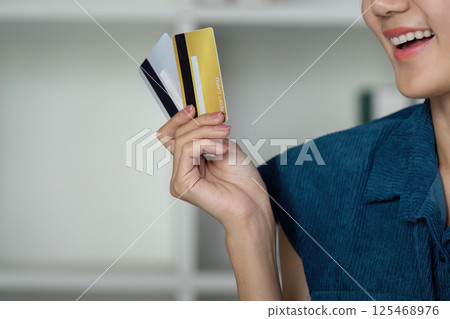 Credit Management and Financial Planning. A smiling woman showcases her credit cards, highlighting the importance of credit diversity. Credit Management and Financial Planning. A smiling woman showcases her credit cards, highlighting the importance of credit diversity. 125468976