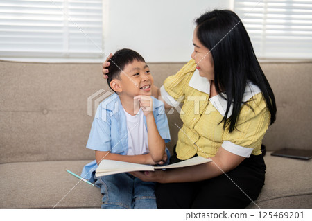 Back to School and Joyful Interactions. A mother and son enjoying a lighthearted moment while studying. 125469201