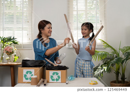 Eco-consciousness and Creativity. Engaging in recycling, a mother and daughter create lasting memories while promoting eco-friendliness. 125469449