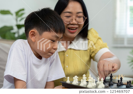 Activity mother son playing chess at home Activity mother son playing chess at home 125469707