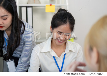 Two female professionals exchanging ideas and smiles during a collaborative meeting in a contemporary office Two female professionals exchanging ideas and smiles during a collaborative meeting in a contemporary office 125469829