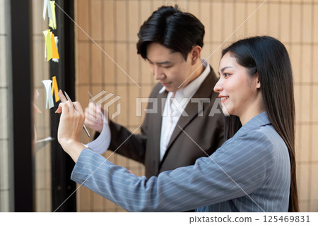 Close-up of team analyzing data on a tablet while discussing project details. Close-up of team analyzing data on a tablet while discussing project details. 125469831
