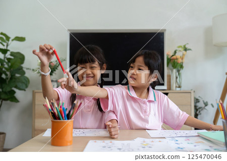 Creative Learning and Friendship. Two girls sharing art supplies while coloring together. 125470046
