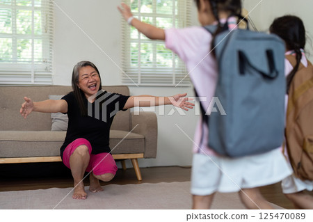Joyful Reunion and Family Love. A mother welcomes her children home from school with open arms. 125470089