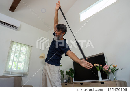Wellness focus on elderly man stretching with resistance band Wellness focus on elderly man stretching with resistance band 125470106