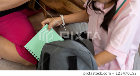 Back to School and Family Bonding. Children preparing their school bags with a caregiver. Back to School and Family Bonding. Children preparing their school bags with a caregiver. 125470152