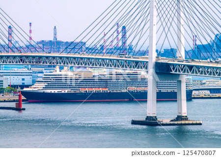 Yokohama cityscape in Japan, overlooking the luxury cruise ship Queen Elizabeth at Daikoku Pier (four luxury cruise ships in Yokohama) = April 26th Yokohama cityscape in Japan, overlooking the luxury cruise ship Queen Elizabeth at Daikoku Pier (four luxury cruise ships in Yokohama) = April 26th 125470807