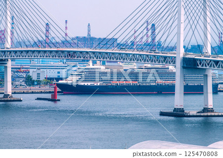 Yokohama cityscape in Japan, overlooking the luxury cruise ship Queen Elizabeth at Daikoku Pier (four luxury cruise ships in Yokohama) = April 26th Yokohama cityscape in Japan, overlooking the luxury cruise ship Queen Elizabeth at Daikoku Pier (four luxury cruise ships in Yokohama) = April 26th 125470808